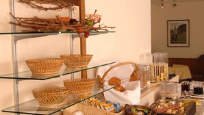 A buffet setup with wicker baskets, bread, fruits, and condiments.