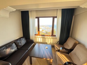 Suite familiar, no fumadores, balcón | Zona de estar | Una televisión de pantalla plana