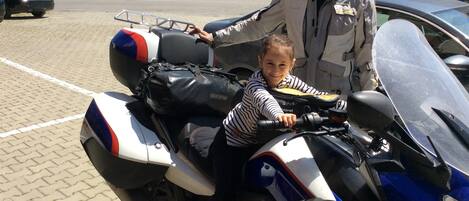 Un niño sentado en una motocicleta con un hombre de pie a su lado.