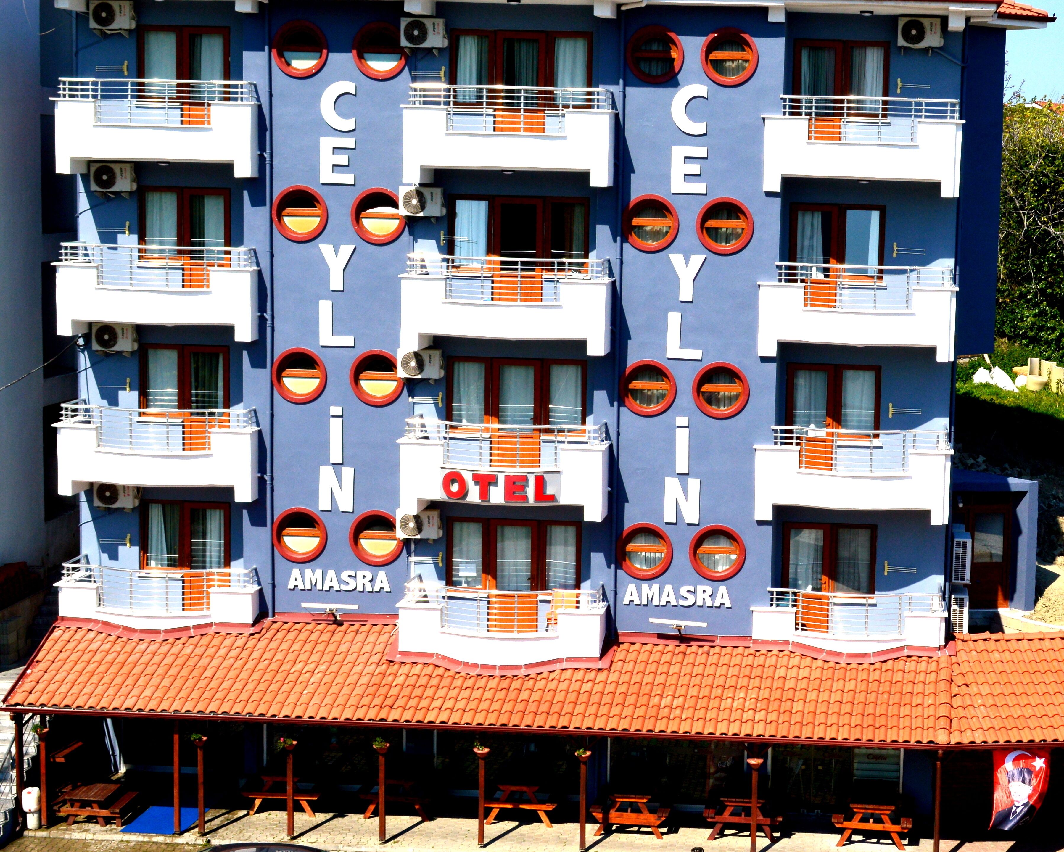 A hotel with balconies, a red-tiled roof, and the name 'AMASRA' on the facade.