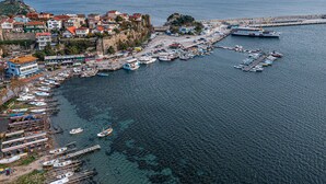 A coastal town with a marina filled with boats, a pier, and buildings along the waterfront. - Amasra Ceylin Hotel (Amasra)