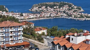 A coastal town with a prominent hotel featuring balconies and a view of the sea. - Amasra Ceylin Hotel (Amasra)