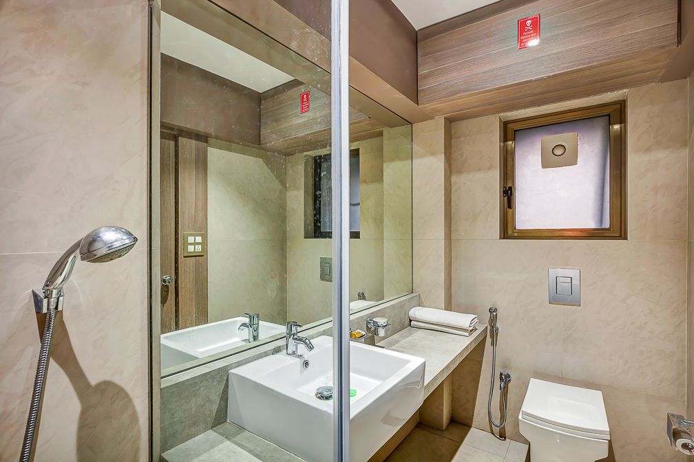 Un baño moderno con dos lavamanos, ducha, inodoro y espejo.