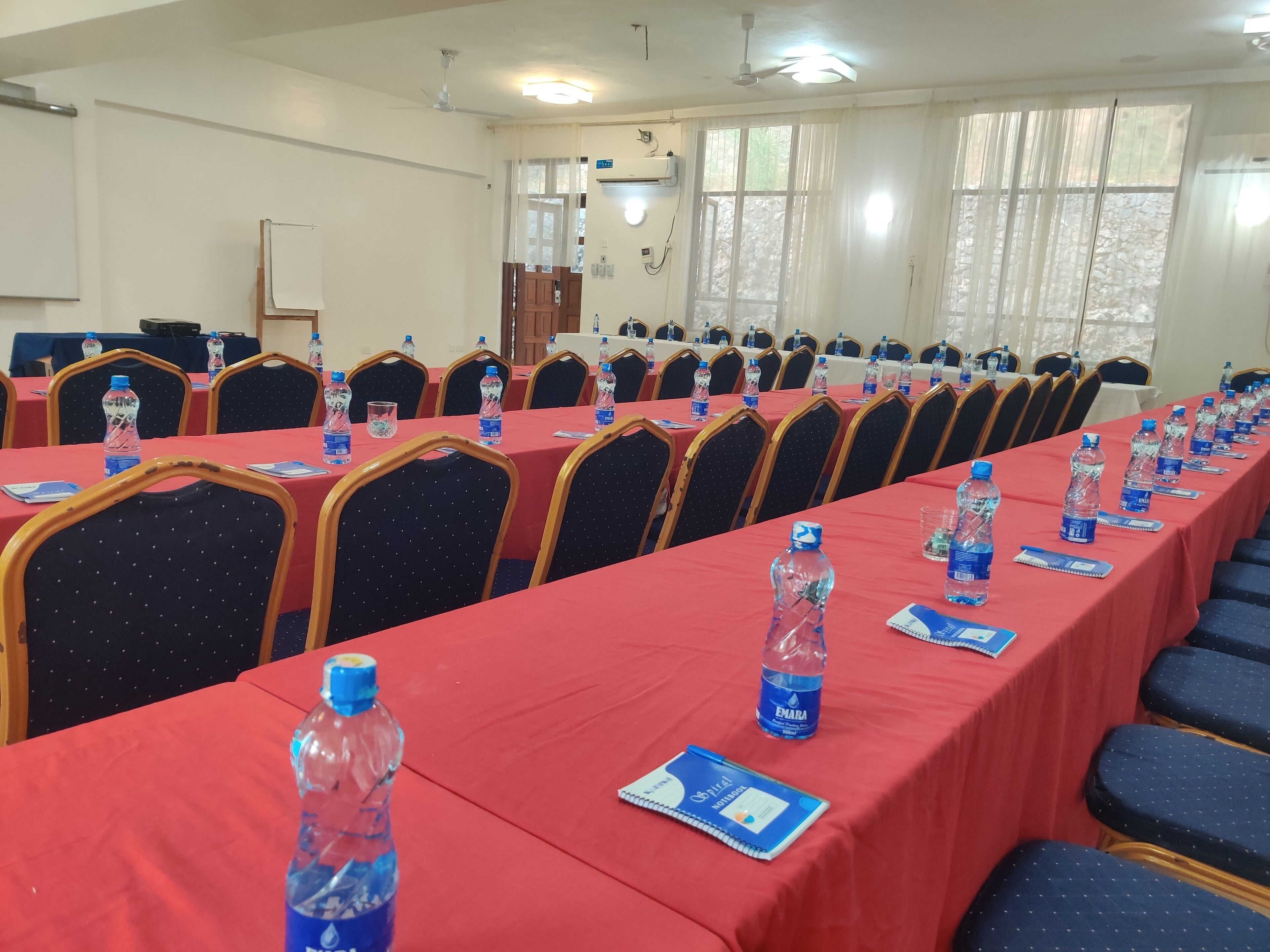 A conference room with long tables, chairs, water bottles, and nameplates.