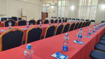 A conference room with long tables, chairs, water bottles, and nameplates.