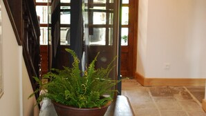 Un banco de madera con una planta en maceta en el centro de un pasillo.