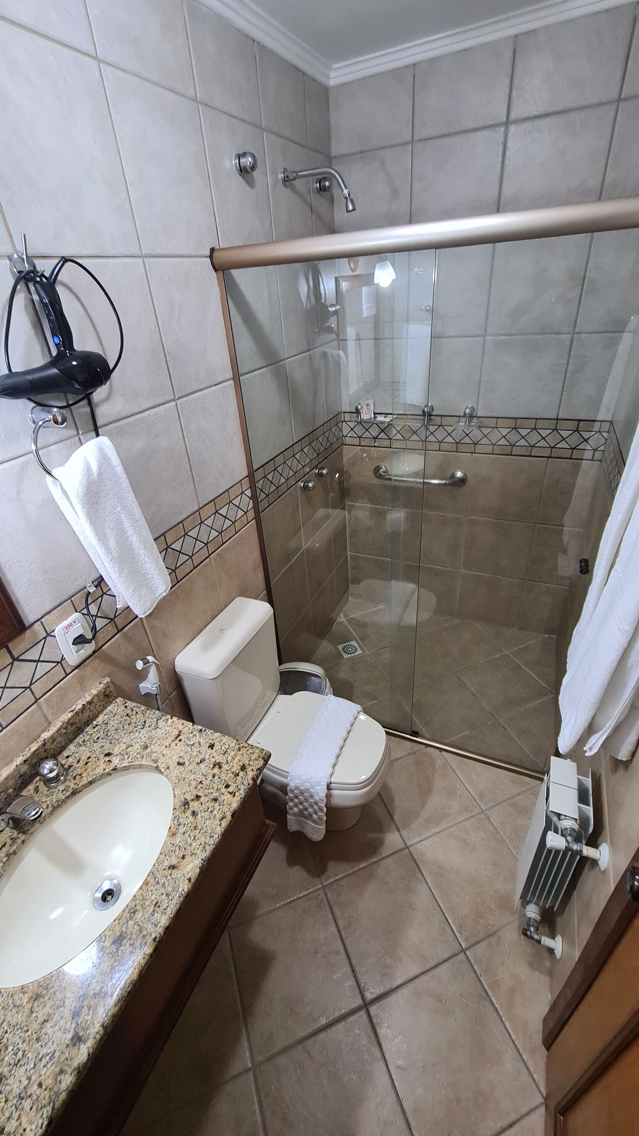 Un baño con ducha, inodoro y lavamanos.