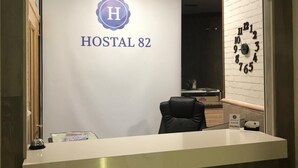 A reception desk with a sign that reads "RECEPCIÓN" and "HOSTAL 82". - Hostal 82 (Olias del Rey)