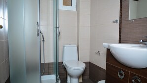 Une salle de bain moderne avec une douche à parois de verre, des toilettes et un lavabo.