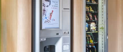 A vending machine with snacks and a coffee machine, and a B&B hotel sign above it.