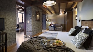 Een gezellige woonkamer met een open haard, een bank en een eethoek met een dienblad eten.
