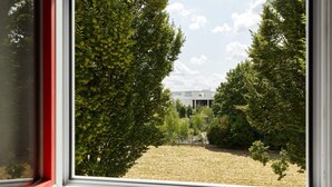 A view through a window with a building labeled "CEFAA" in the background, surrounded by trees. - B&B HOTEL Paris Nord Villepinte (Villepinte)