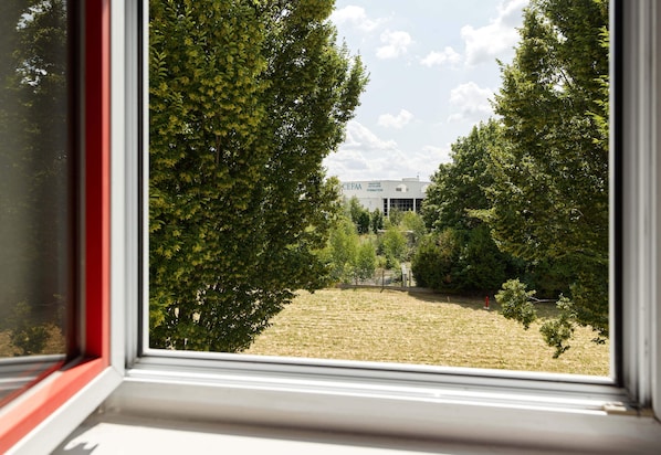 A view through a window with a building labeled "CEFAA" in the background, surrounded by trees.