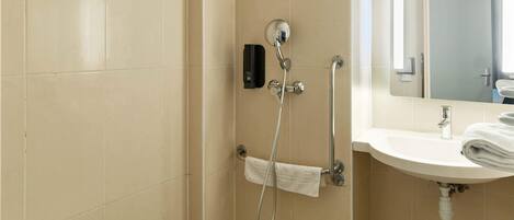 A bathroom with a shower, a sink, and a mirror.