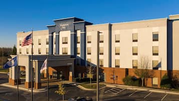 Experience the Hampton Inn's sleek, symmetrical design, featuring a mix of brick and light-colored panels.