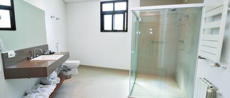A modern bathroom with a glass-enclosed shower, a vanity with a mirror, and a toilet.