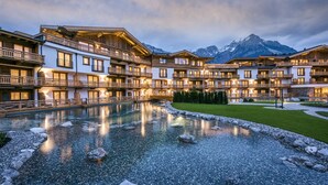 Un hôtel doté de nombreux balcons, d’une piscine et offrant une vue sur les montagnes.