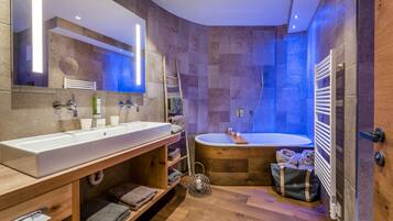 A modern bathroom with a large sink, a bathtub, and a shower.