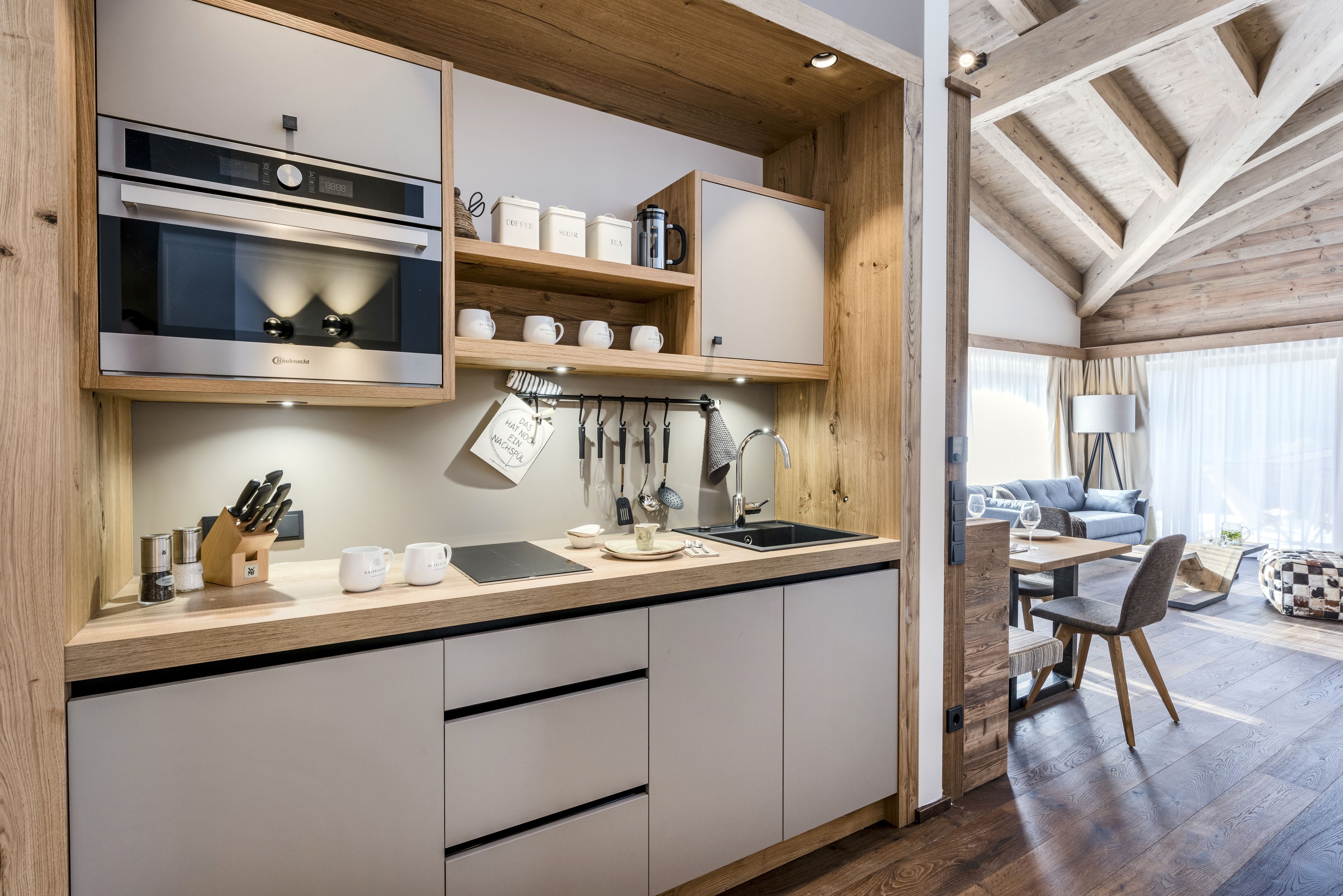 Eine moderne Küche mit eingebauten Geräten, Holzschränken und einem Essbereich mit Tisch und Stühlen.