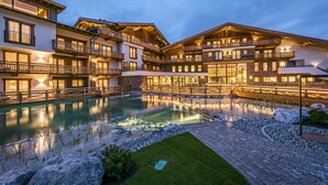Un hôtel à plusieurs étages doté d’une piscine, d’un espace extérieur aménagé et d’un jardin bien entretenu.