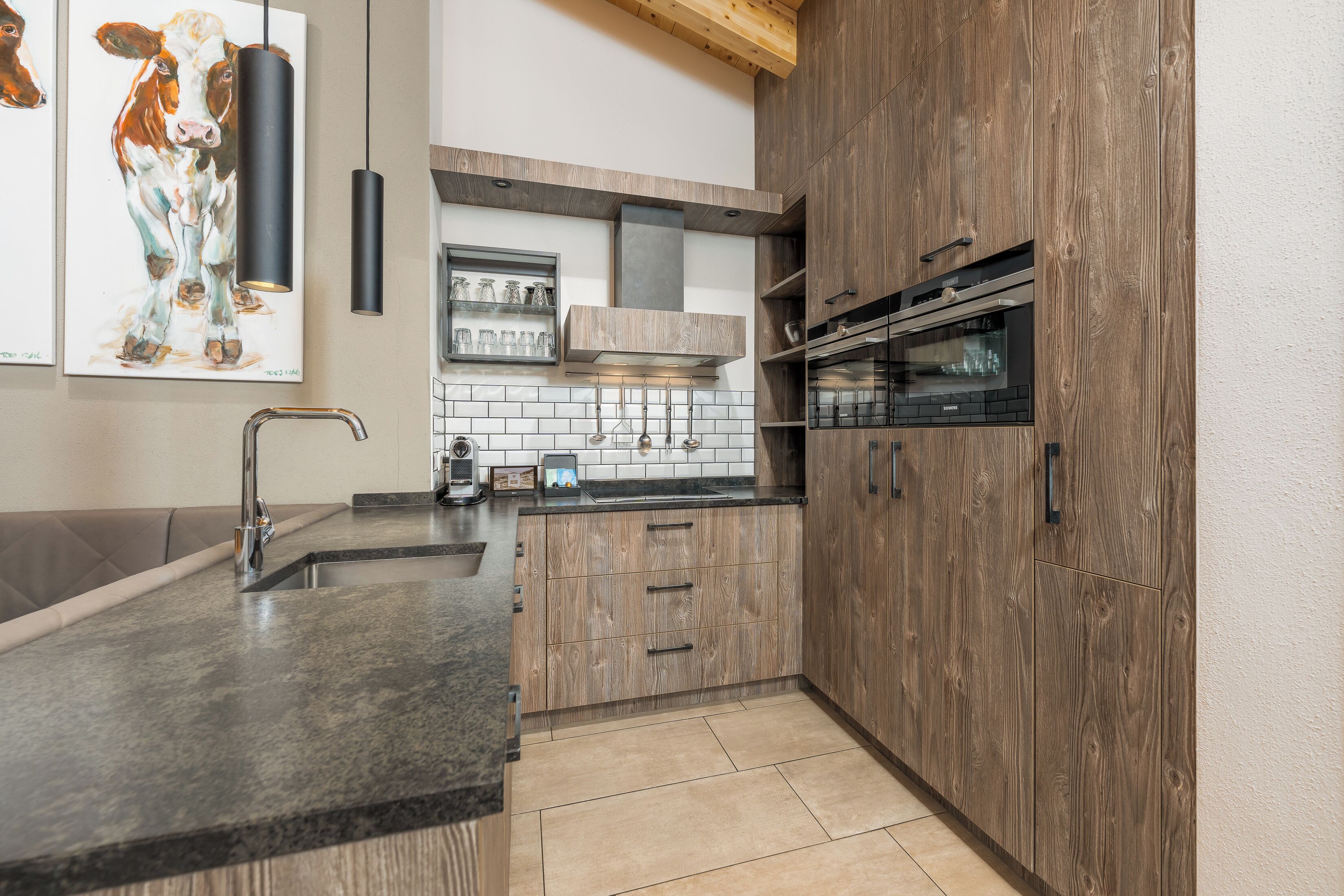 Una cocina moderna con armarios de madera, encimera de granito y electrodomésticos de acero inoxidable.