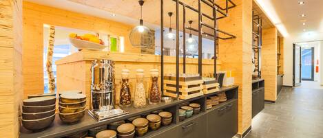 A modern kitchen with wooden accents, a variety of bowls, and hanging pendant lights.