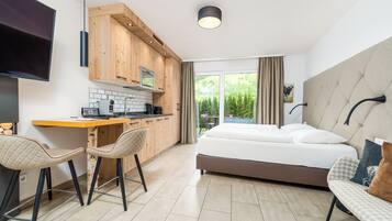 Una habitación de hotel moderna con cama, sofá, escritorio y televisor.