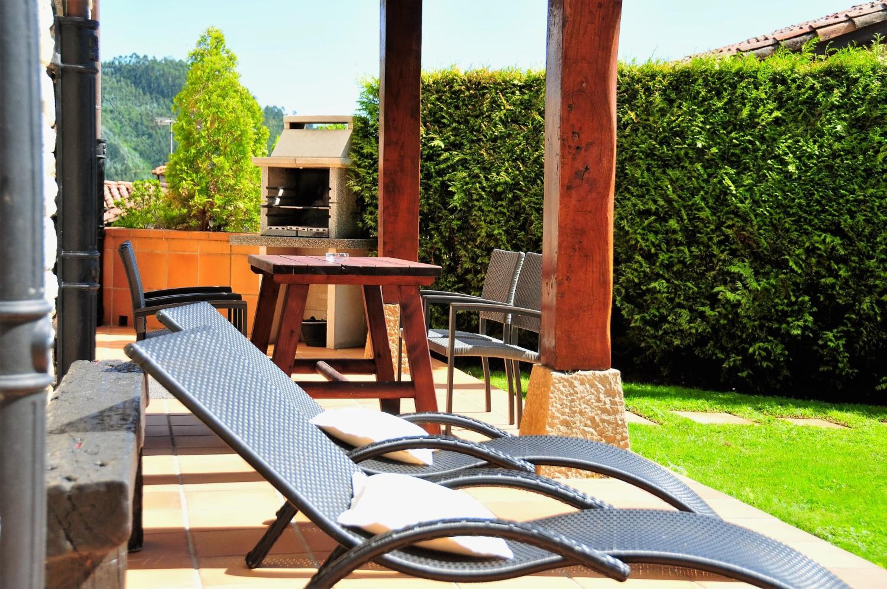 A patio with a table, chairs, and a grill.