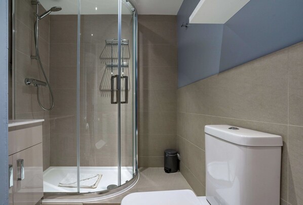 A modern bathroom with a glass-enclosed shower, a toilet, and a sink. - Budock Vean Hotel (Falmouth)