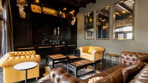 Una sala de estar moderna con sofás de cuero, una mesa redonda de centro y una chimenea.