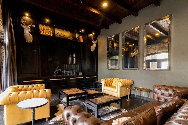 A modern living room with leather sofas, a round coffee table, and a fireplace.