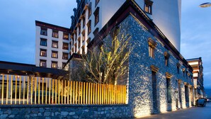 A multi-story building with a stone facade and traditional architectural elements. - Hilton Garden Inn Shangri-La (Deqin)