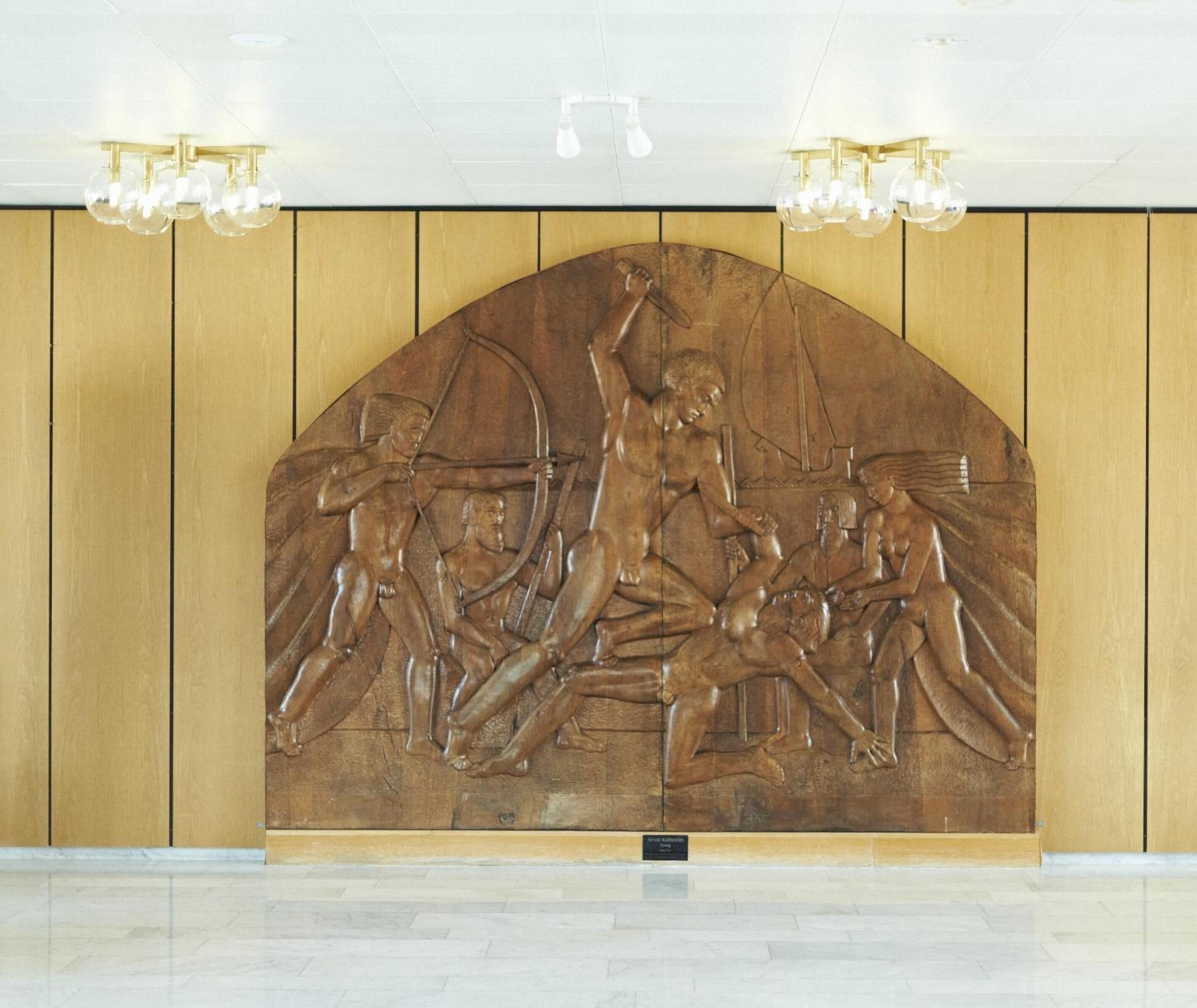 A wall with a relief sculpture depicting a historical scene.