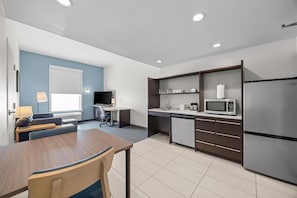 A modern kitchen with a dining area, a flat-screen TV, and a microwave. - Home2 Suites By Hilton Maumee Toledo (Maumee)