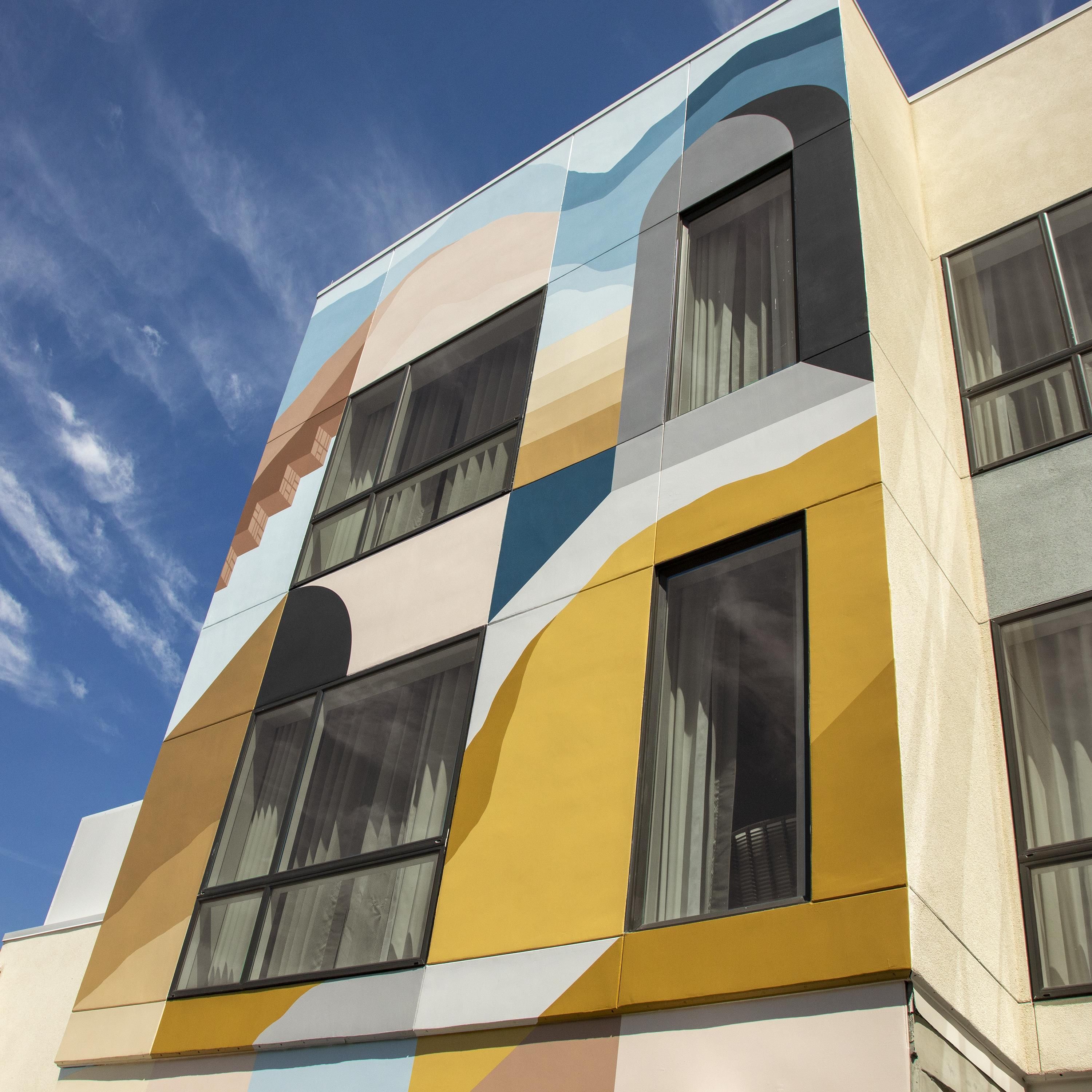 A building with a modern facade featuring geometric patterns and multiple windows.