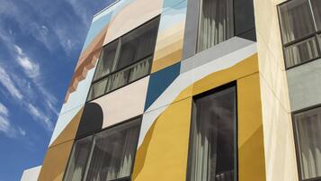 A building with a modern facade featuring geometric patterns and multiple windows.