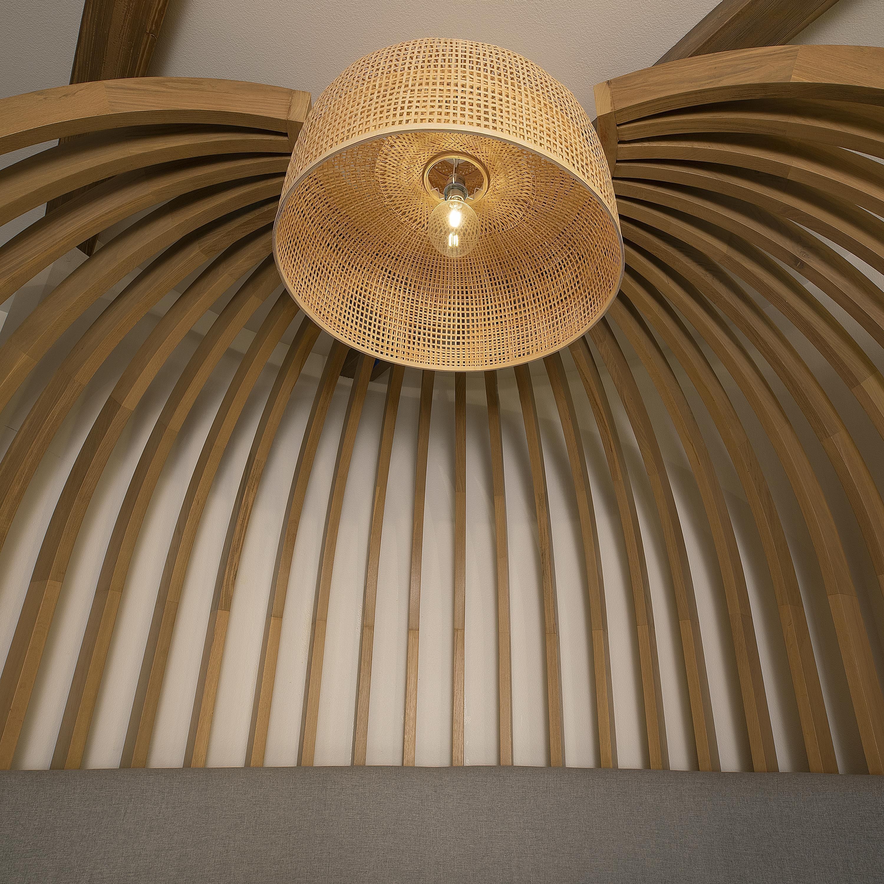 Un plafond agrément é d’un luminaire tressé et de lambris en bois.