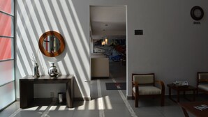 A hotel lobby with a reception desk, a mirror, and seating area. - HS Hotel (Tepeapulco)