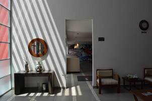 Um saguão de hotel com balcão de recepção, espelho e área de estar.