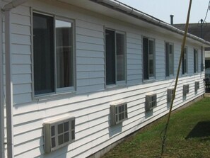 A single-story white building with multiple windows and vents. - Chapel Hill Motel (Moran)
