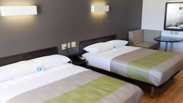 Une chambre d’hôtel avec deux lits simples, une petite table et une chaise.