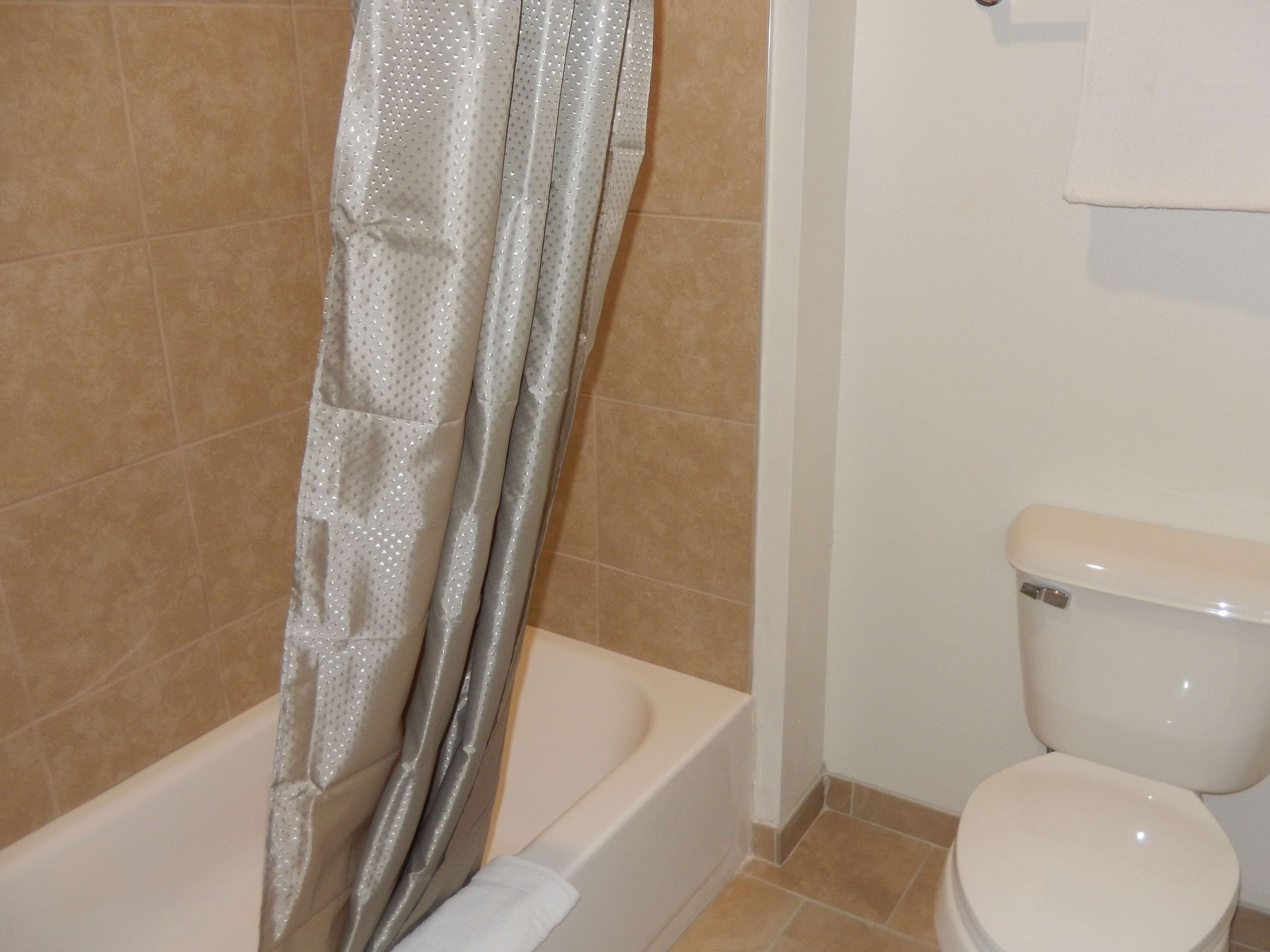 Une salle de bain avec une baignoire, des toilettes et des murs carrelés.