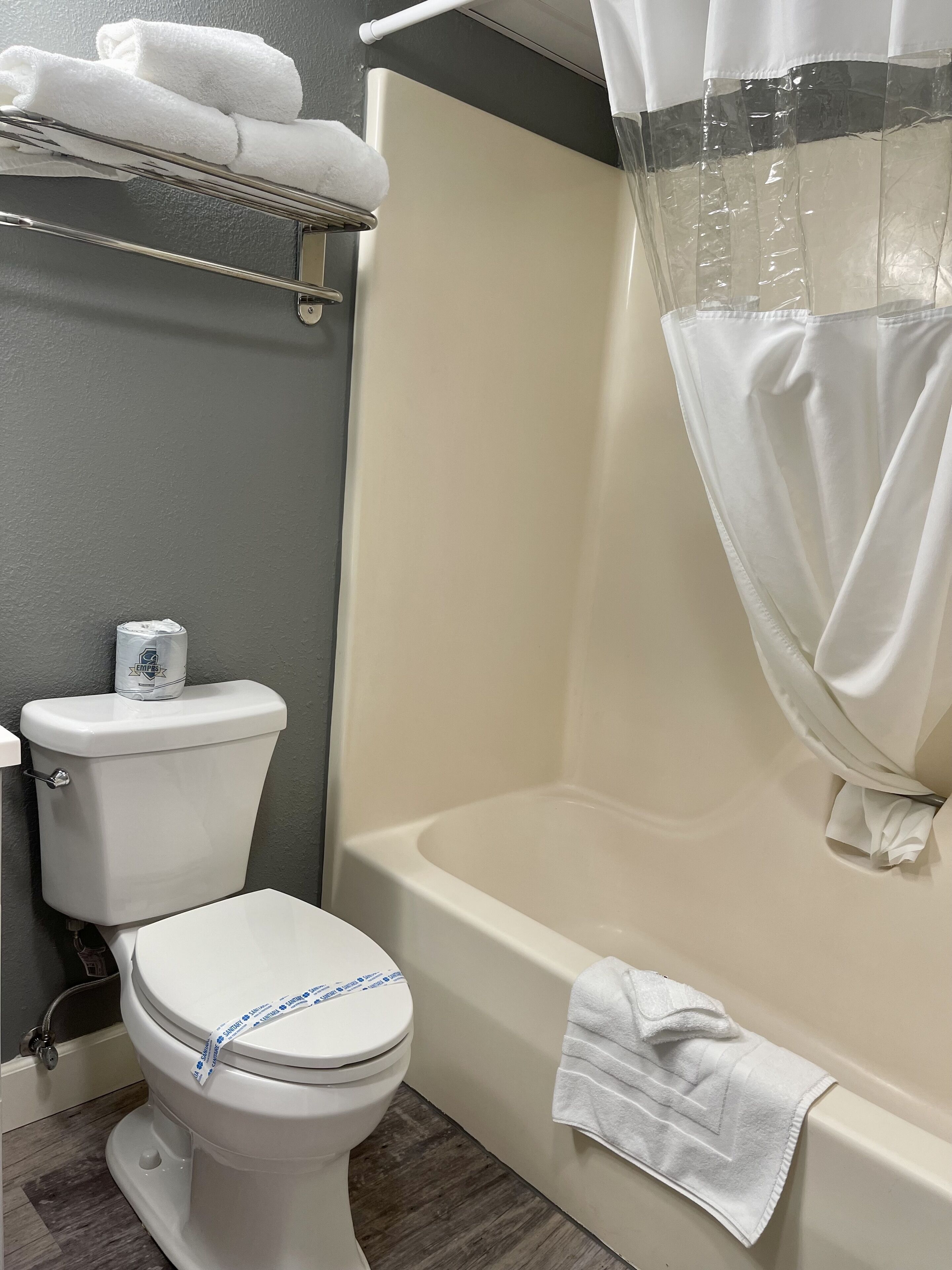 Un baño con inodoro, bañera y cortina de ducha.