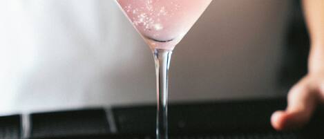 Ein Martini-Glas mit Limettenscheibe auf einer schwarzen, strukturierten Oberfläche.