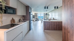 Uma cozinha moderna com ilha central, eletrodomésticos embutidos e vista para o exterior.