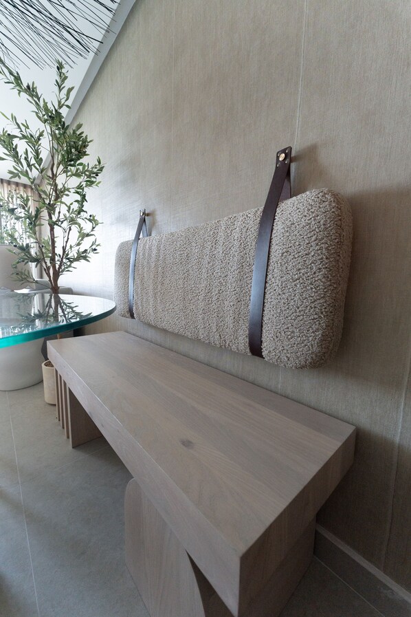 A modern seating area with a bench and a wall-mounted cushion.
