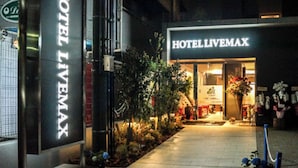 Una entrada de hotel con un letrero que dice "HOTEL LIVERMAX" y otro letrero que dice "HOTELLIVEMAX".
