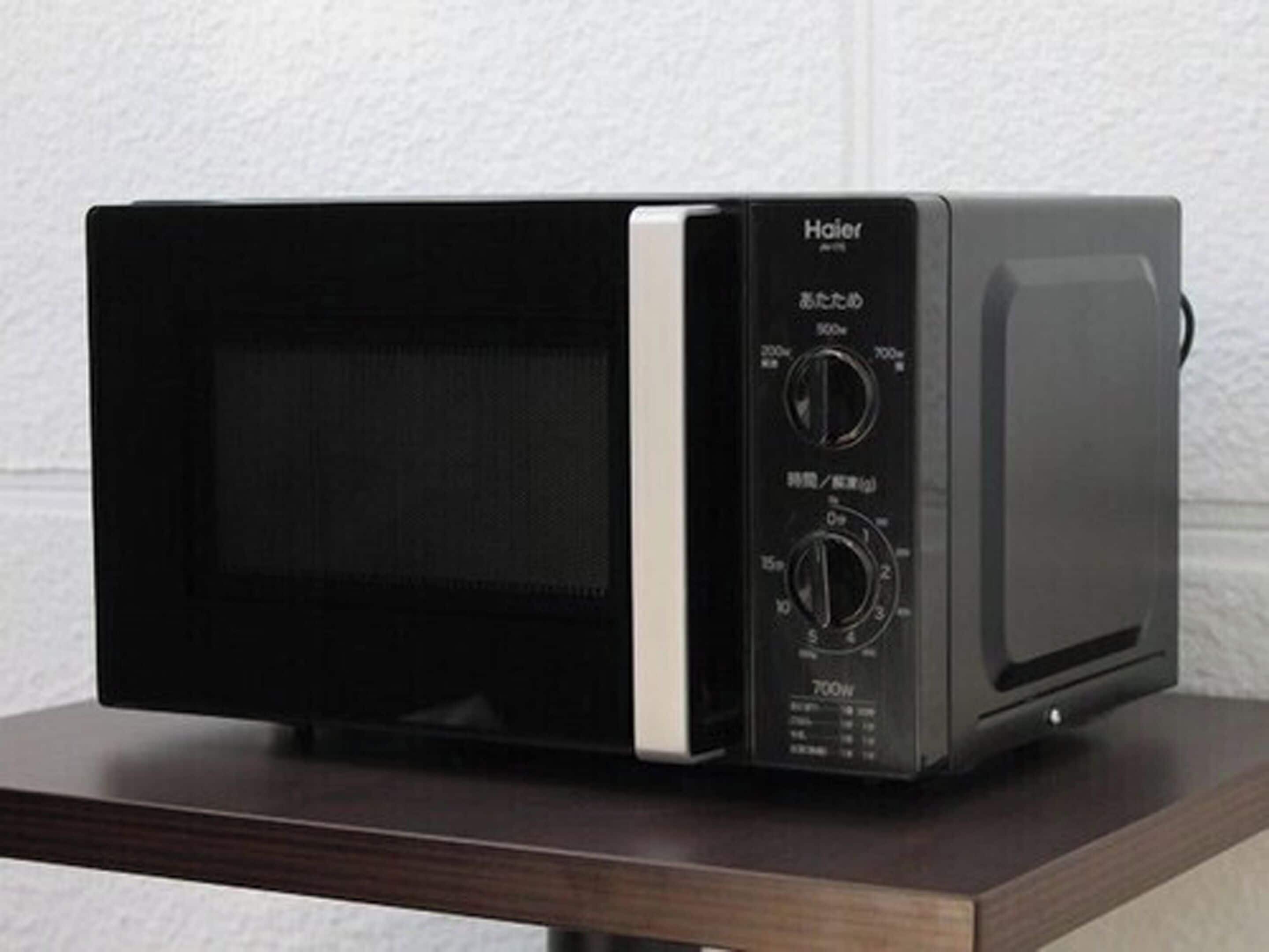 A black and silver microwave oven on a wooden surface.