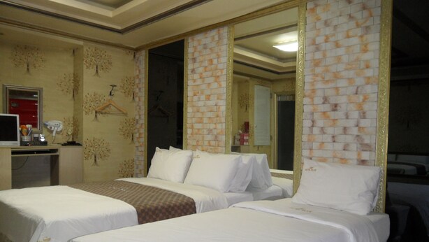 A hotel room with two beds, a desk with a computer, and a mirror. - Songdo Blue Hotel (Incheon)