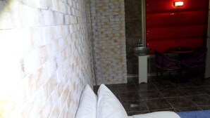 A hotel room with a bed, a small table, and a red wall. - Songdo Blue Hotel (Incheon)